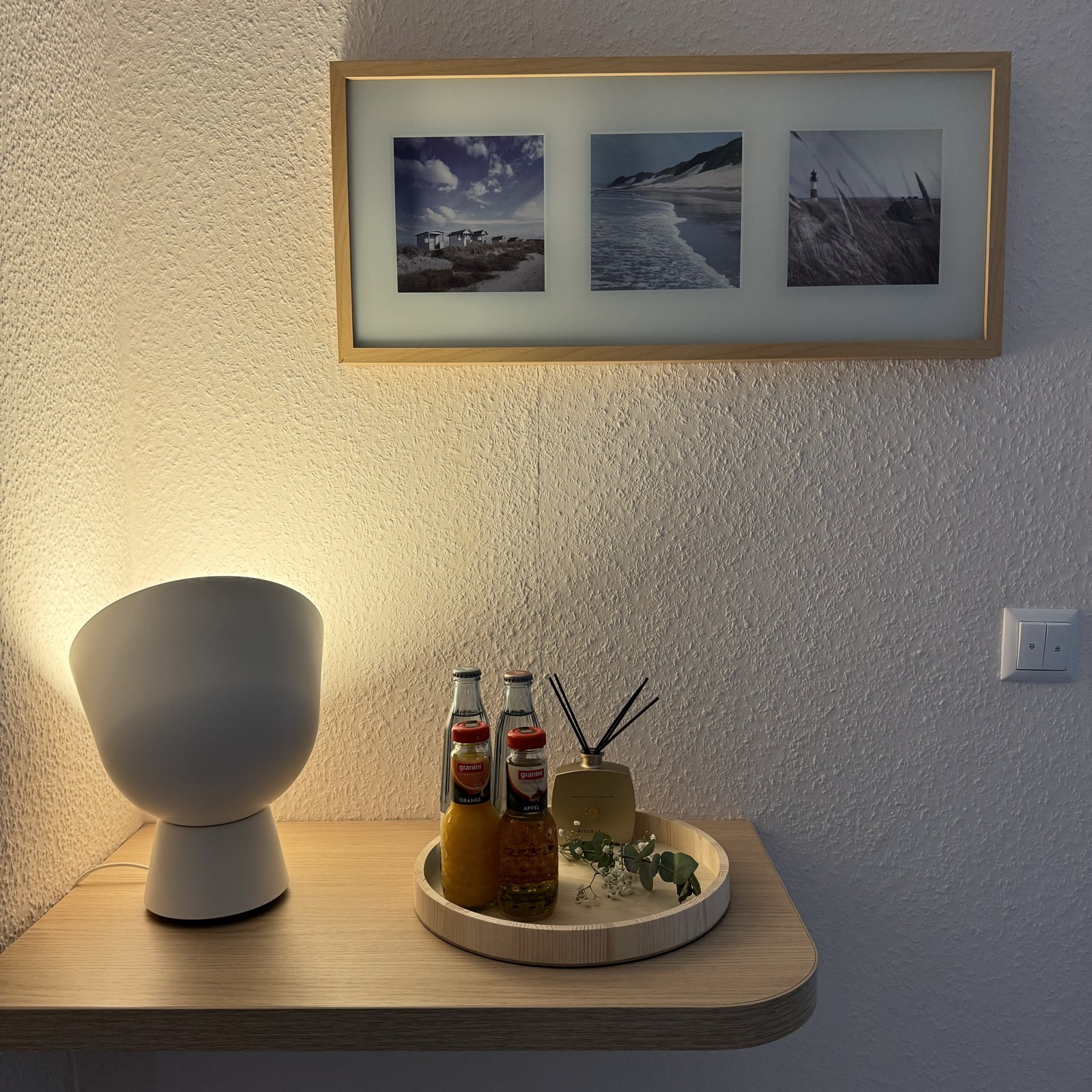 Ablage mit Bilderrahmen, Lampe und Getränken