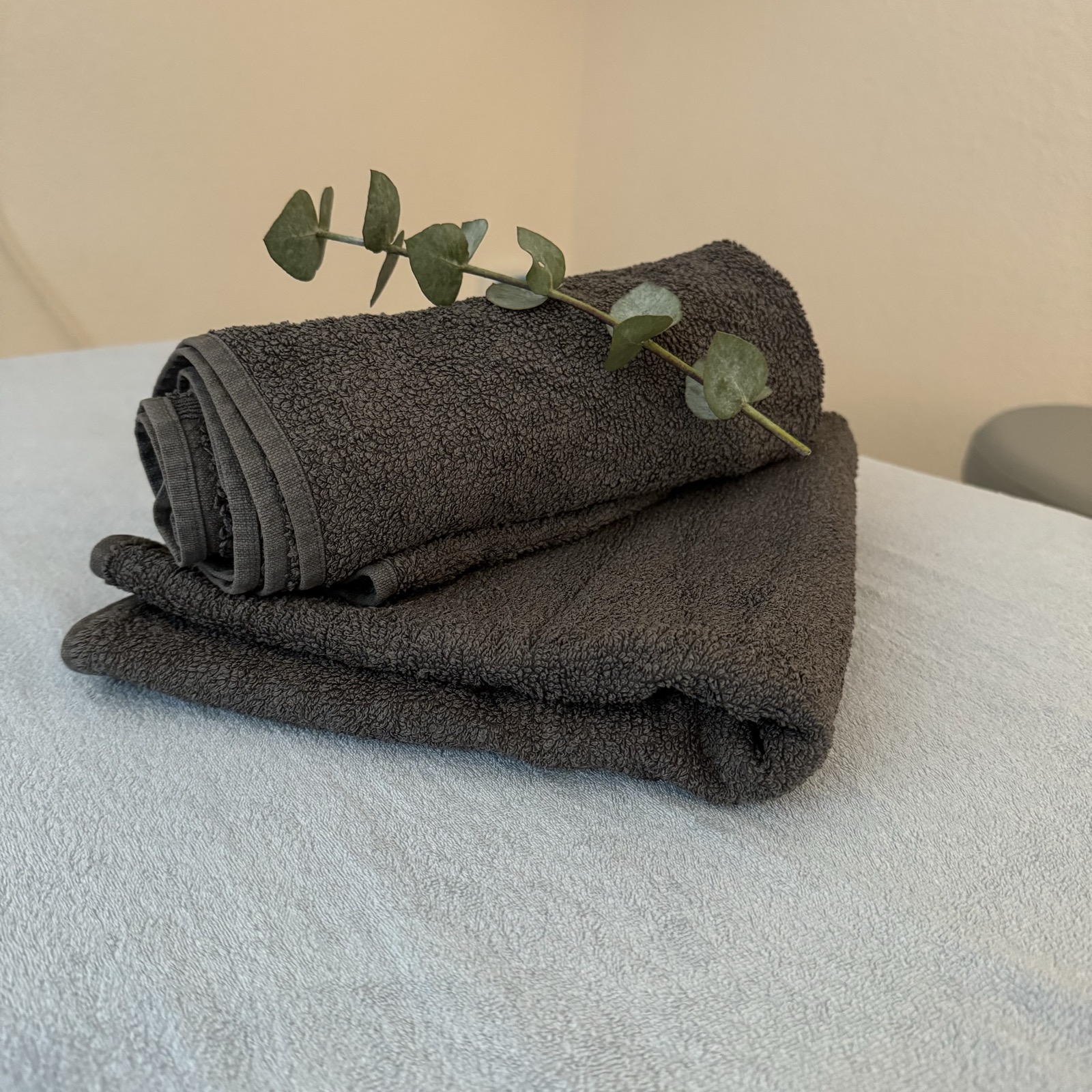 Zusammengelegtes Handtuch mit Eukalyptuszweig